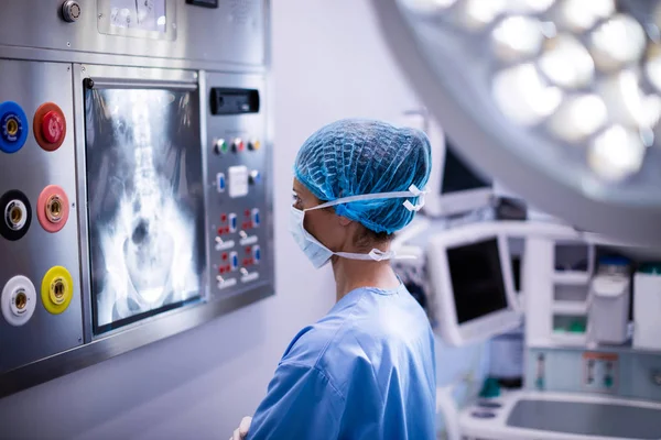 Vrouwelijke chirurg lezing x-ray — Stockfoto