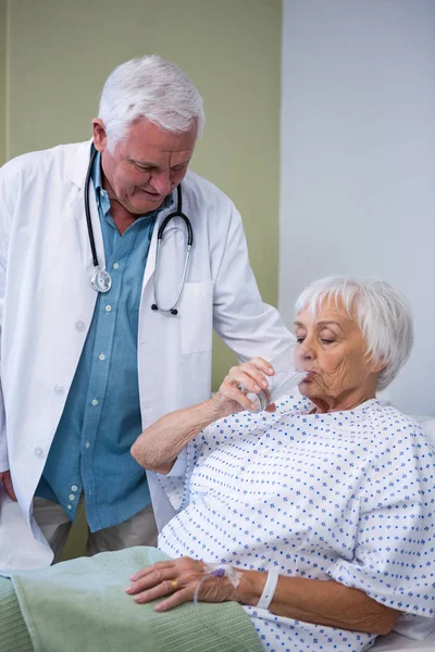 Seniorin trinkt ein Glas Wasser — Stockfoto
