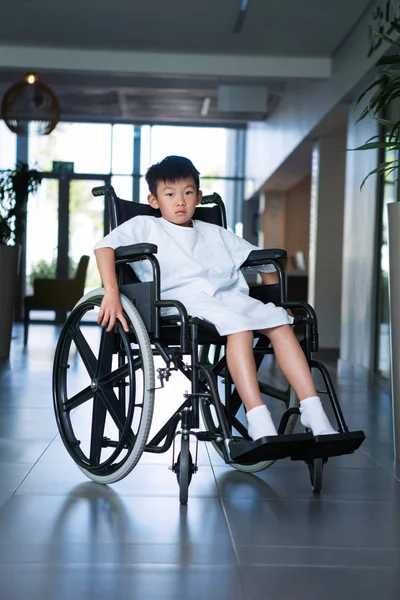 Paciente niño discapacitado en silla de ruedas en el pasillo del hospital —  Fotos de Stock