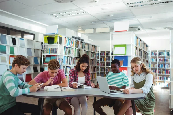 Colegas atentos estudando na biblioteca — Fotografia de Stock