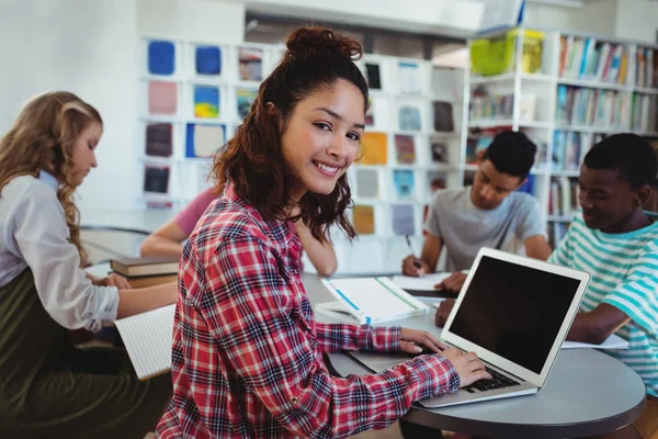 Colegiala utilizando el ordenador portátil con sus compañeros de clase — Foto de Stock