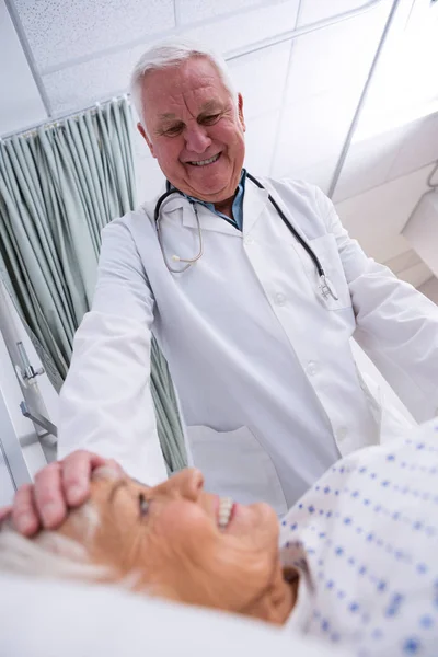 Läkare tröstande äldre patient — Stockfoto