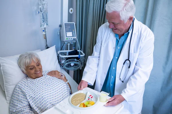 Läkare som serverar frukost och medicin till patienten — Stockfoto