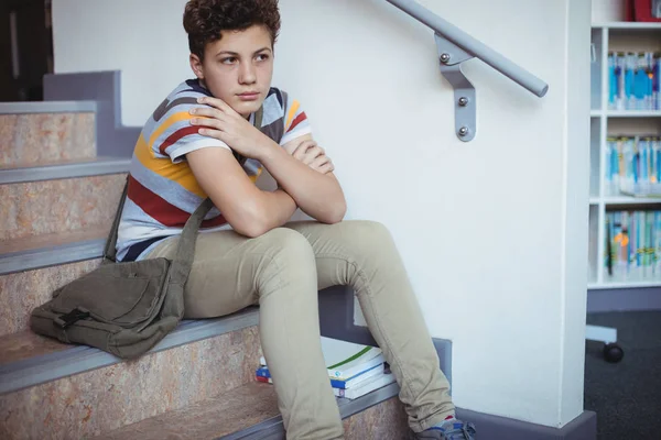 Sorgliga skolpojke sitter ensam på trappan — Stockfoto