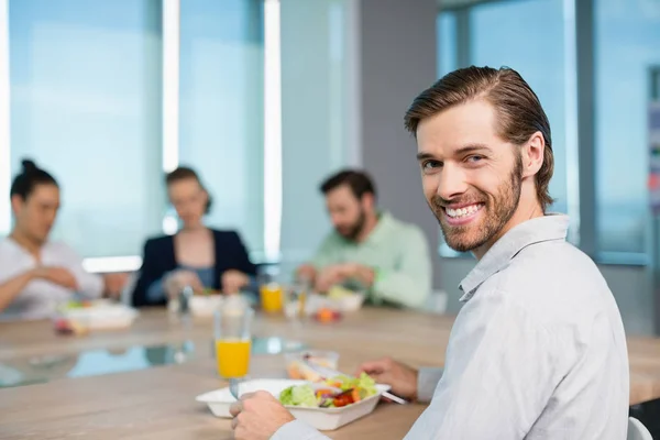 Sonriente ejecutivo de negocios comiendo — Foto de Stock