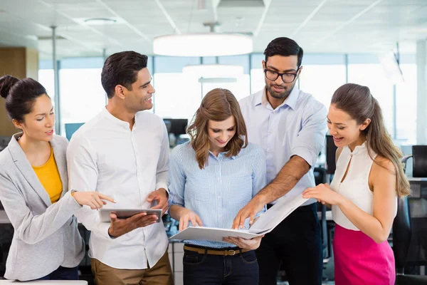 Compañeros de negocios discutiendo sobre portapapeles — Foto de Stock