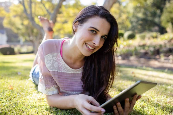 Mujer acostada sobre hierba y usando tableta —  Fotos de Stock