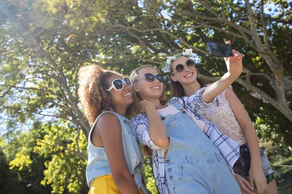 Female friends taking selfie with phone — Stock Photo, Image