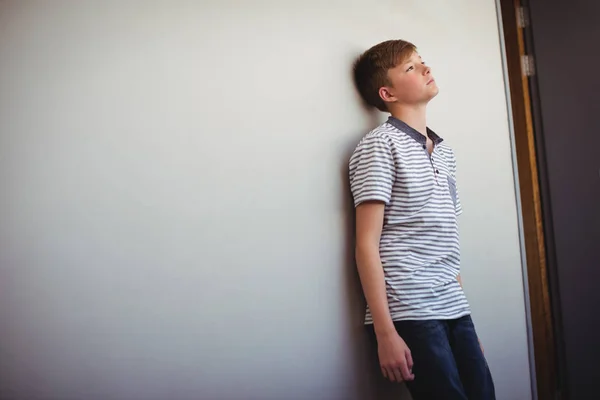 Sad schoolboy leaning head against wall — Stock Photo, Image