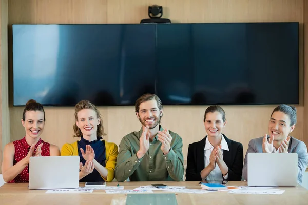 Glimlachend business team applaudisseren tijdens vergadering — Stockfoto