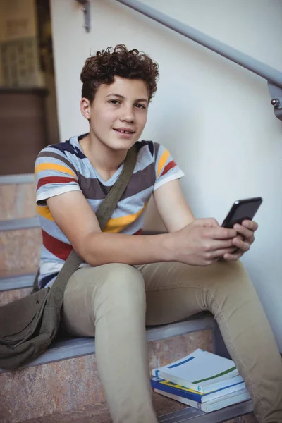 Écolier assis sur l'escalier et utilisant le téléphone — Photo