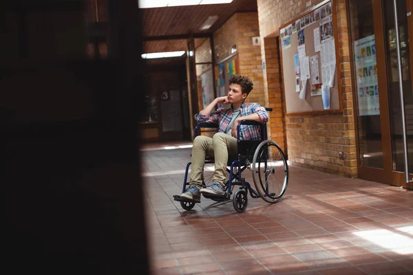 Écolier handicapé en fauteuil roulant dans le couloir — Photo