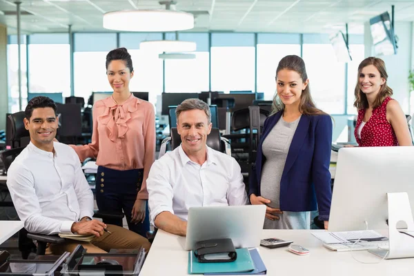 Geschäftskollegen stehen zusammen am Schreibtisch — Stockfoto