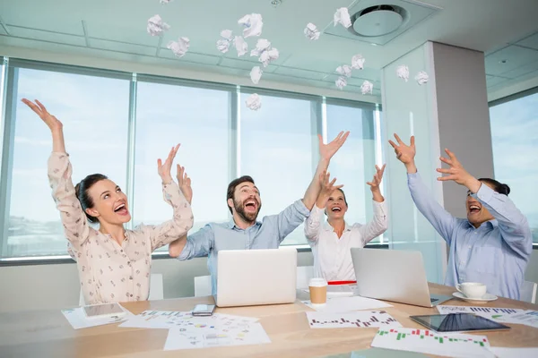 Ejecutivos de negocios lanzando papel arrugado en el aire — Foto de Stock