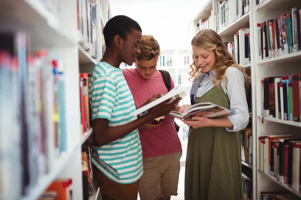 Skolbarnen läsa böcker i biblioteket i skolan — Stockfoto