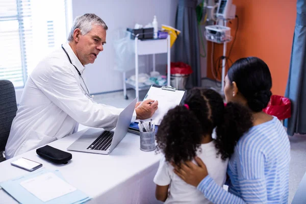 Médico y paciente discutiendo sobre portapapeles —  Fotos de Stock