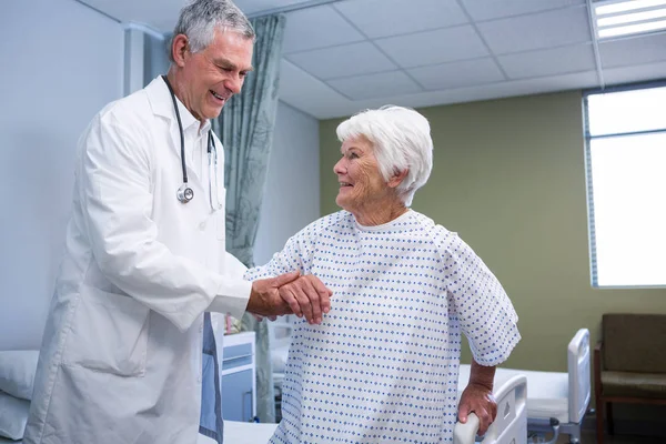 Dokter meewerkende senior patiënt in ward — Stockfoto