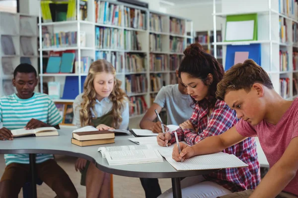 Attente klasgenoten studeren in de bibliotheek — Stockfoto