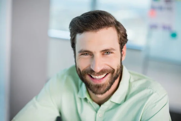 Exécutif d'entreprise souriant assis au bureau — Photo