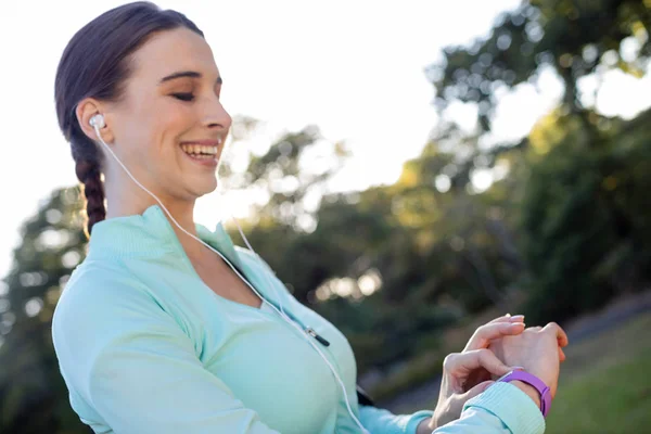 Kvinnliga joggaren kontrollera hennes fitness band — Stockfoto