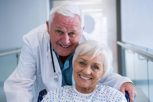 Doctor holding senior patient on wheelchair — Stock Photo, Image