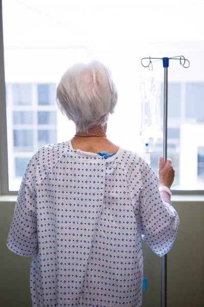 Задумчивый пожилой пациент, стоящий в больнице — стоковое фото