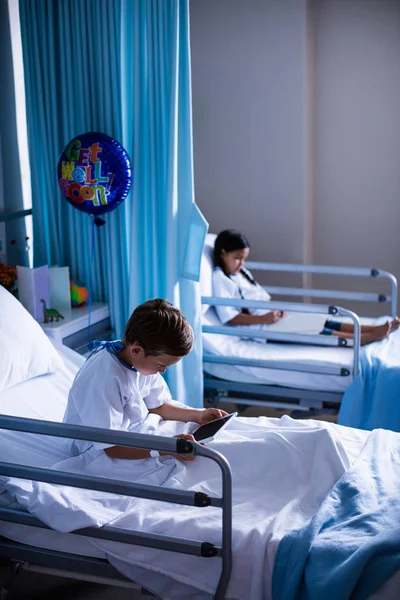Dijital tablet ve yatakta kitap olan hastalar — Stok fotoğraf