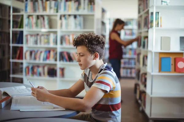 Attentive schoolboy using mobile phone — Stock Photo, Image