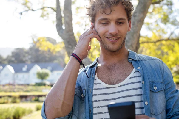 Man luisteren naar muziek in park — Stockfoto