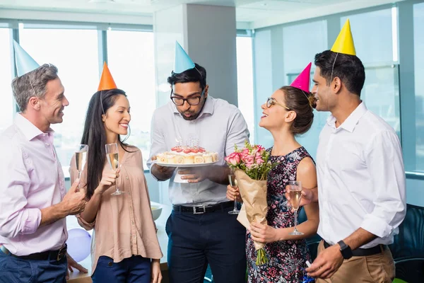 Compañeros de negocios sonrientes celebrando cumpleaños — Foto de Stock