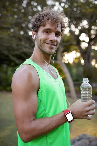 Jogger sosteniendo botella de agua en el parque —  Fotos de Stock