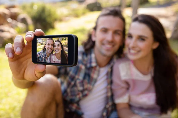 Couple clicking a picture on mobile phone — Stock Photo, Image
