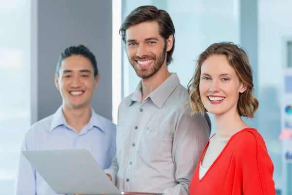 Business executives smiling while standing in office — Stock Photo, Image