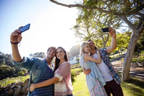 Parejas haciendo clic en una selfie en el parque — Foto de Stock