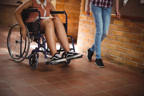 Estudante com seu amigo deficiente no corredor — Fotografia de Stock