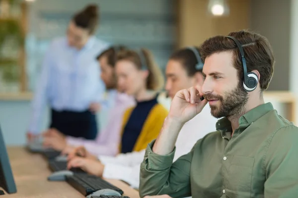 Executivos de atendimento ao cliente que trabalham em call center — Fotografia de Stock