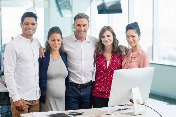 Business colleagues standing together at desk — Stock Photo, Image