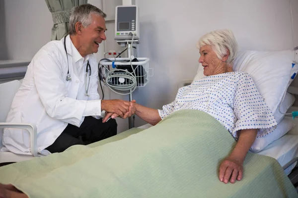 Врач осматривает старшего пациента в палате — стоковое фото