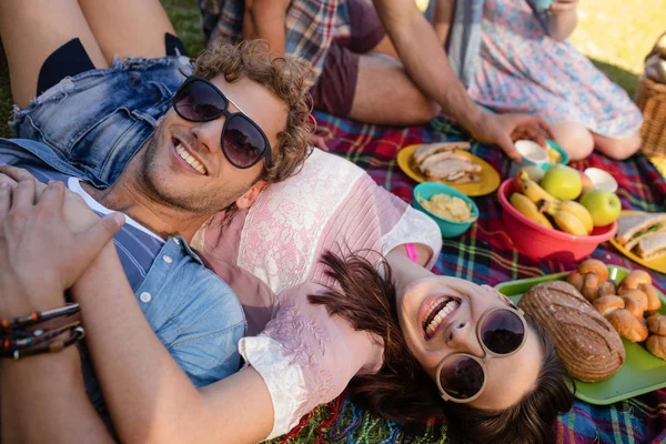 Par avkopplande i parken samtidigt ha picknick — Stockfoto
