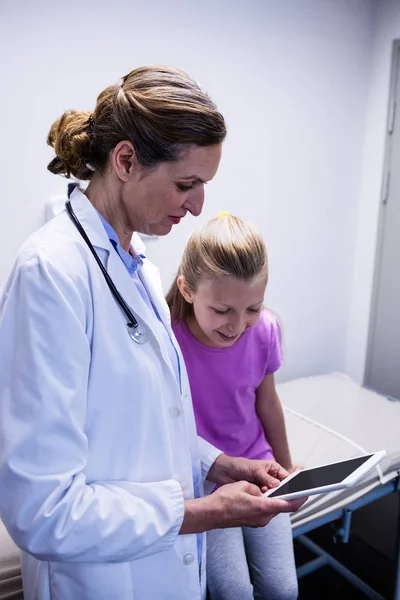 Médico mostrando informe médico en tableta al paciente — Foto de Stock