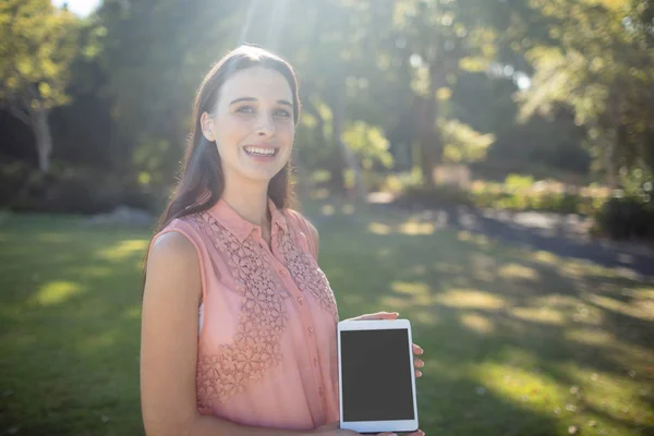 Woman holding tablet in the park — Stock Photo, Image