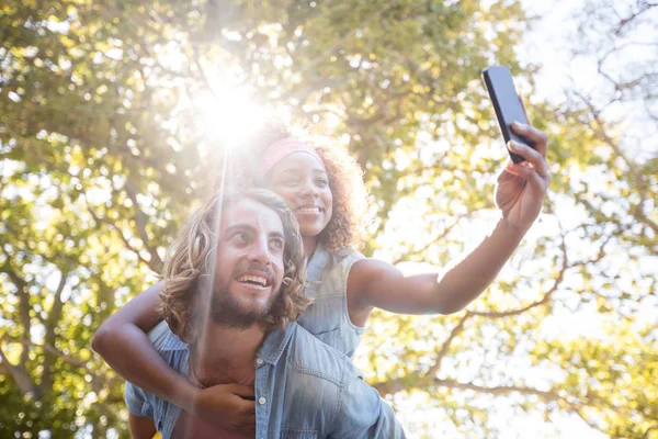 Pareja tomando selfie mientras disfruta de paseo a cuestas —  Fotos de Stock