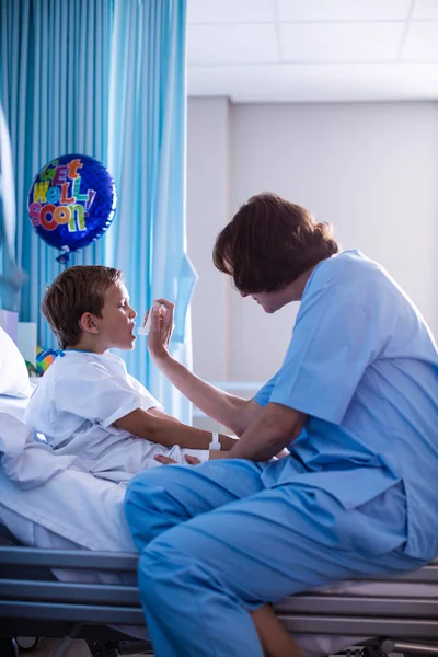 Vrouwelijke arts met behulp van de inhalator op patiënt — Stockfoto