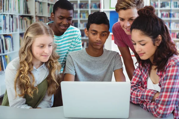 Attente klasgenoten via laptop in bibliotheek — Stockfoto