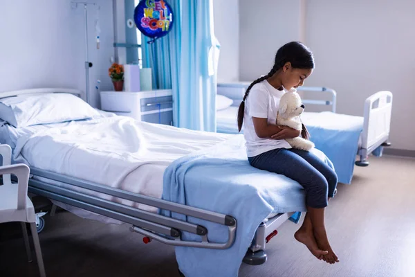 Patient sitting on bed with teddy bear — Stock Photo, Image