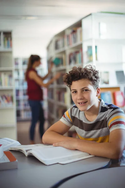 Gelukkig schooljongen studeren in de bibliotheek — Stockfoto