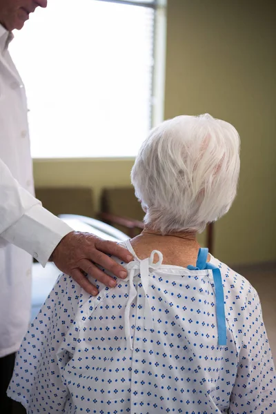 Läkare tröstande äldre patient — Stockfoto