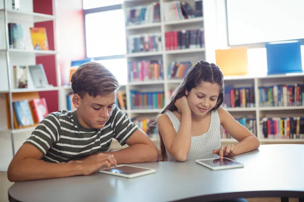 Uczniowie za pomocą cyfrowego tabletu w bibliotece — Zdjęcie stockowe