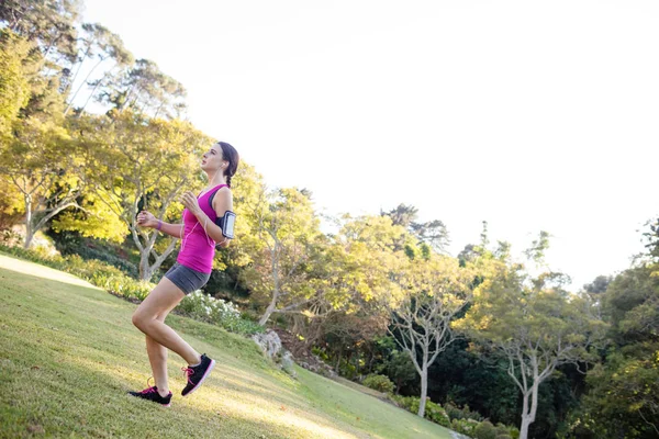 Kadın koşucu koşu sırasında müzik — Stok fotoğraf