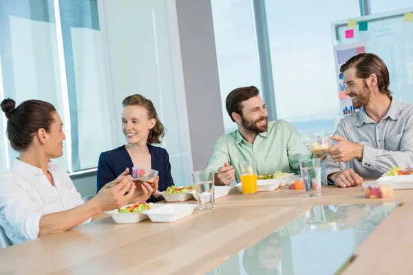 Ejecutivos de negocios sonrientes comiendo — Foto de Stock